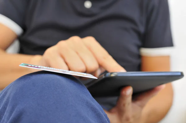 Young man shopping online via a tablet computer — Stock Photo, Image