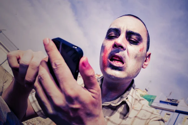 Zombie aterrador usando un teléfono inteligente, con un efecto de filtro — Foto de Stock