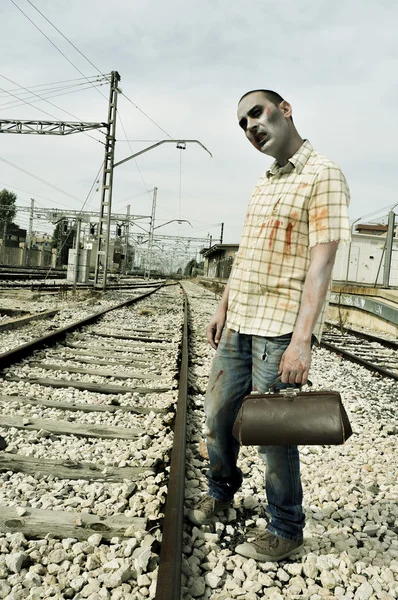 Scary zombie waiting for the train, with a filter effect — Stock Photo, Image