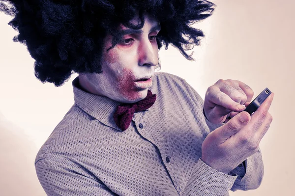 Hipster zombie com um afro usando um smartphone, com um ef filtro — Fotografia de Stock