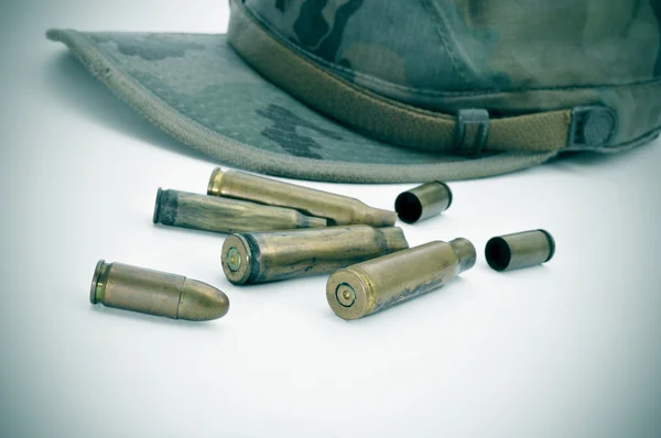 Camouflage cap and bullets — Stock Photo, Image