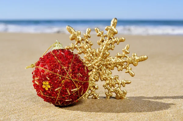 Christmas ball and star on the beach — Stock Photo, Image