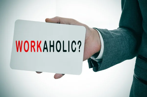 Businessman showing a signboard with the word workaholic — Stock Photo, Image