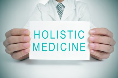 doctor with a signboard with the text holistic medicine clipart