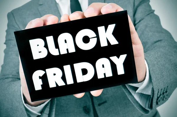 Mannen i kostym med en skylt med texten svart fredag — Stockfoto