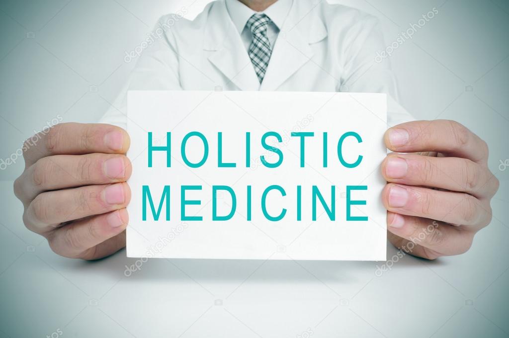 doctor with a signboard with the text holistic medicine