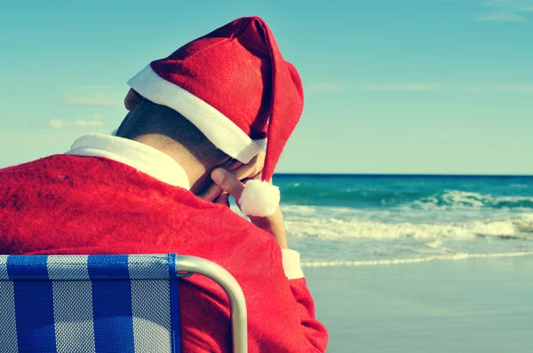 Santa claus tar en tupplur på stranden — Stockfoto