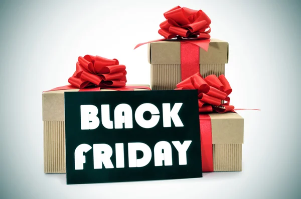 Gifts and a signboard with the text black friday — Stock Photo, Image