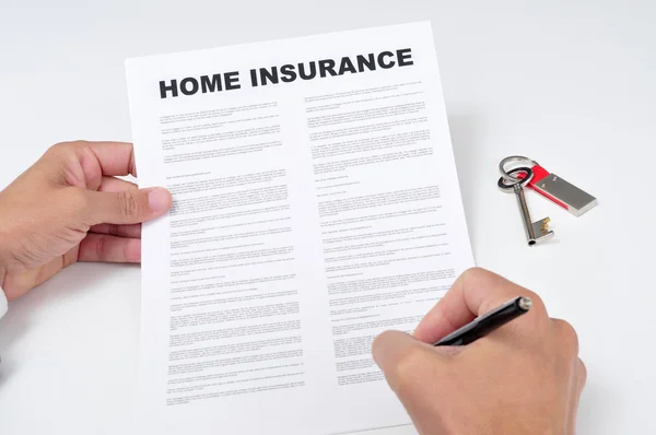 En ung man underteckna en hemförsäkring — Stockfoto