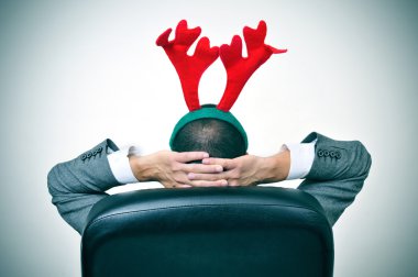 adam onun ofis koltuğu bir Ren geyiği geyik boynuzu kafa bandı ile