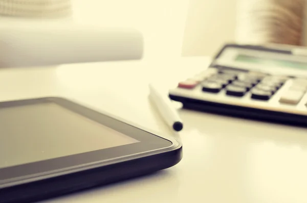 Tablet e calculadora em uma mesa de escritório — Fotografia de Stock
