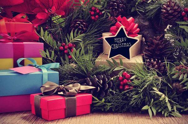 Gifts, christmas wreath and text merry christmas in a star-shape — Stock Photo, Image