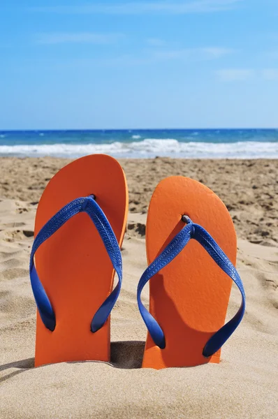 Chanclas en la arena de una playa — Foto de Stock