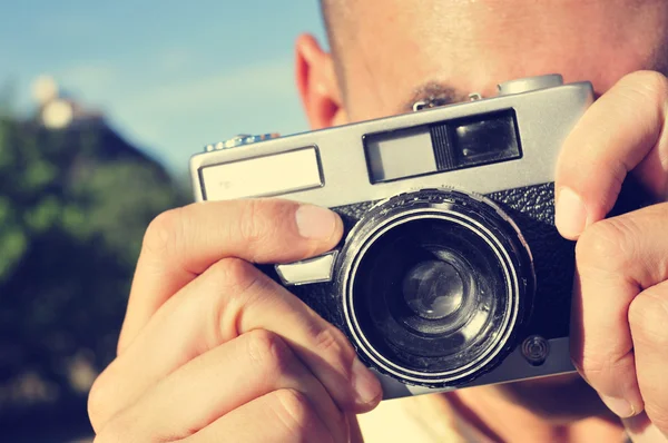 Young man taking a picture with an old camera — Stock Photo, Image