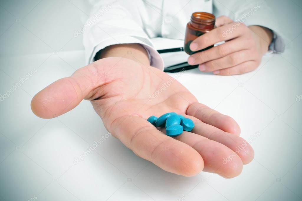 Doctor in a consulting room with a pile of pills