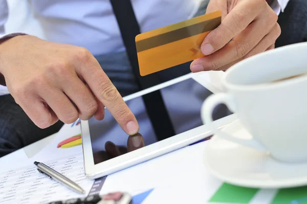 Young man in suit shopping online via a tablet computer — Stock Photo, Image