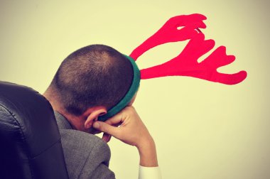 adam ile onun ofis koltuğu bir Ren geyiği geyik boynuzu kafa bandı ile bir