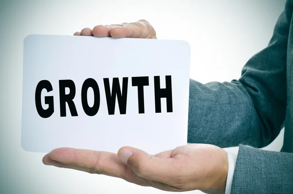 Businessman showing a signboard with the text growth — Stock Photo, Image