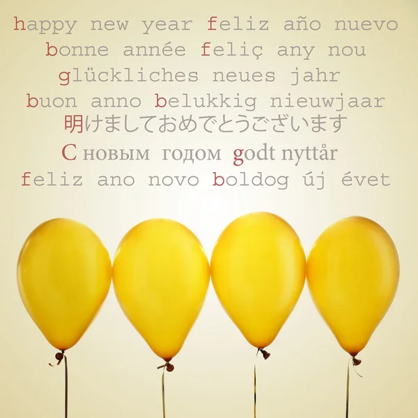 Globos de oro y el texto feliz año nuevo en diferentes idiomas —  Fotos de Stock