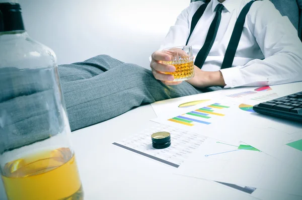 Young businessman drinking in the office — Stock Photo, Image