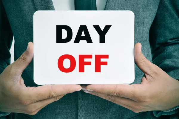 Businessman with a signboard with the text day off — Stock Photo, Image