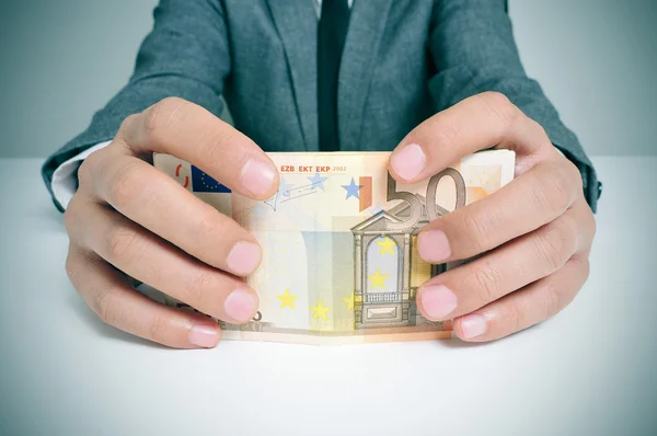 Человек в костюме со счетами евро — стоковое фото