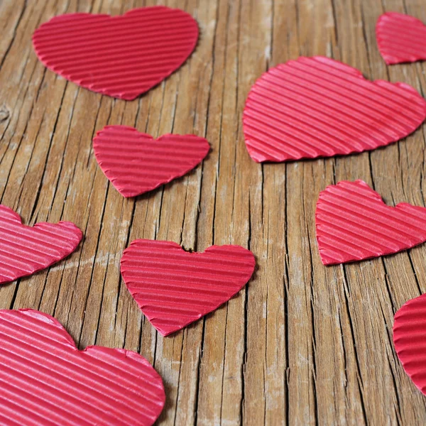 Corações vermelhos em uma superfície de madeira rústica — Fotografia de Stock