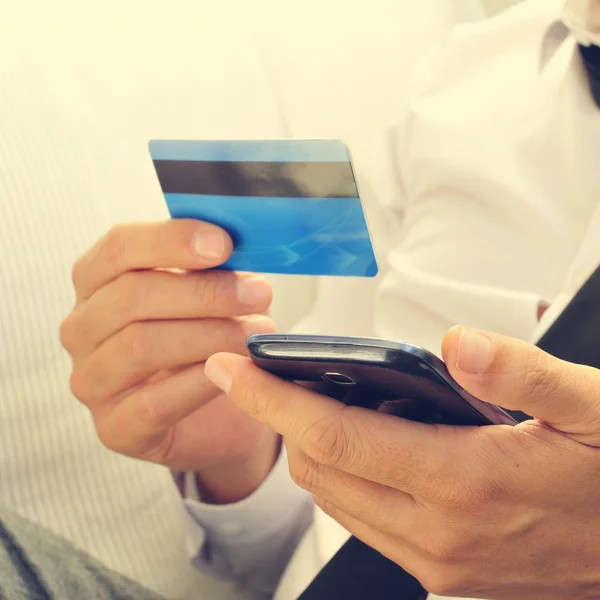 Jovem em terno usando seu cartão de crédito online — Fotografia de Stock