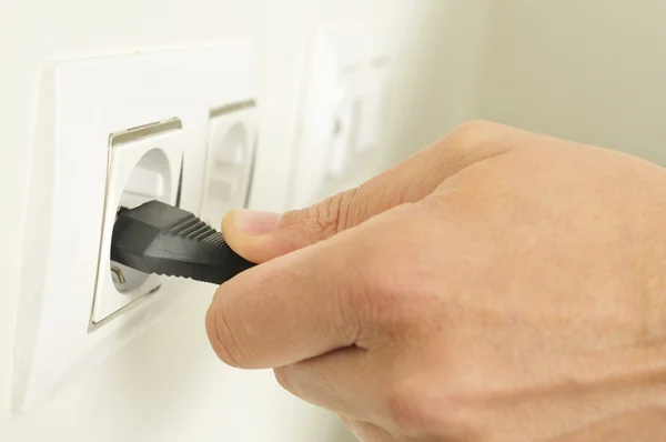 Hombre conectando o desconectando un enchufe eléctrico — Foto de Stock