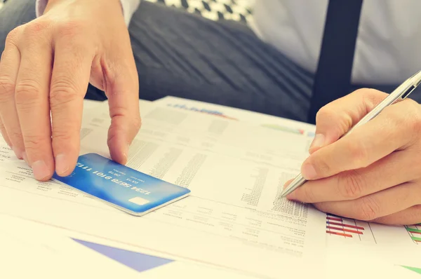 Hombre comprobando la información de su tarjeta de crédito —  Fotos de Stock