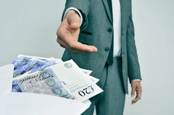 Man taking an envelope full of pound sterling bills — Stock Photo, Image