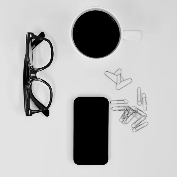 Eyeglasses, smartphone, coffee and heart-shaped paperclips — Stock Photo, Image