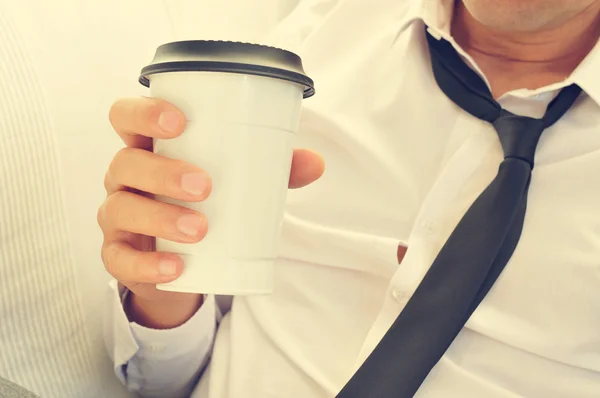 Человек пьет кофе в бумажной чашке — стоковое фото