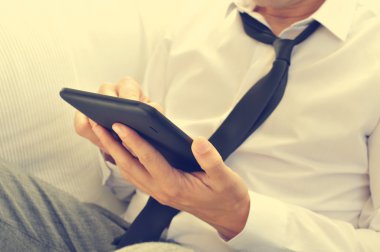 Bir tablet bilgisayar kullanarak rahat genç adam
