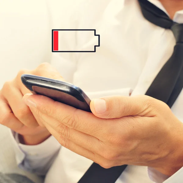 Young man with a smartphone with low battery — Stock Photo, Image