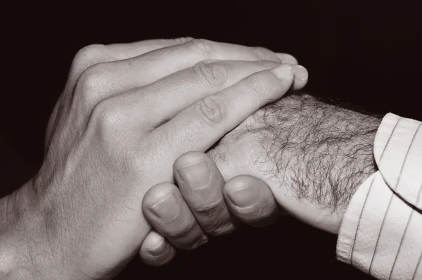 Joven sosteniendo la mano de un anciano — Foto de Stock