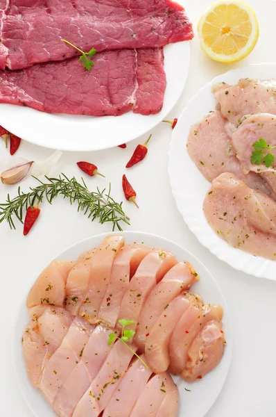 Pratos com carne crua em uma mesa branca — Fotografia de Stock