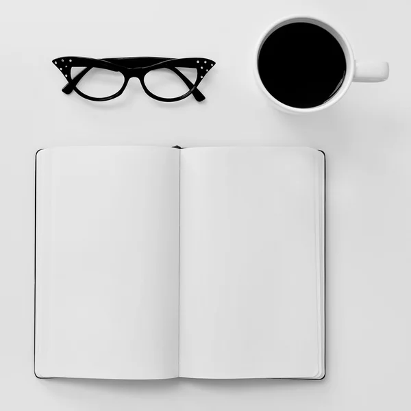 Caderno em branco, óculos e xícara de café — Fotografia de Stock