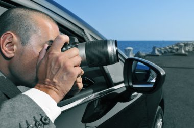 detective or paparazzi taking photos from inside a car clipart