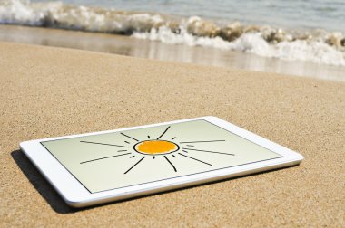 Bir Tablet bir plaj kum çizilmiş güneş