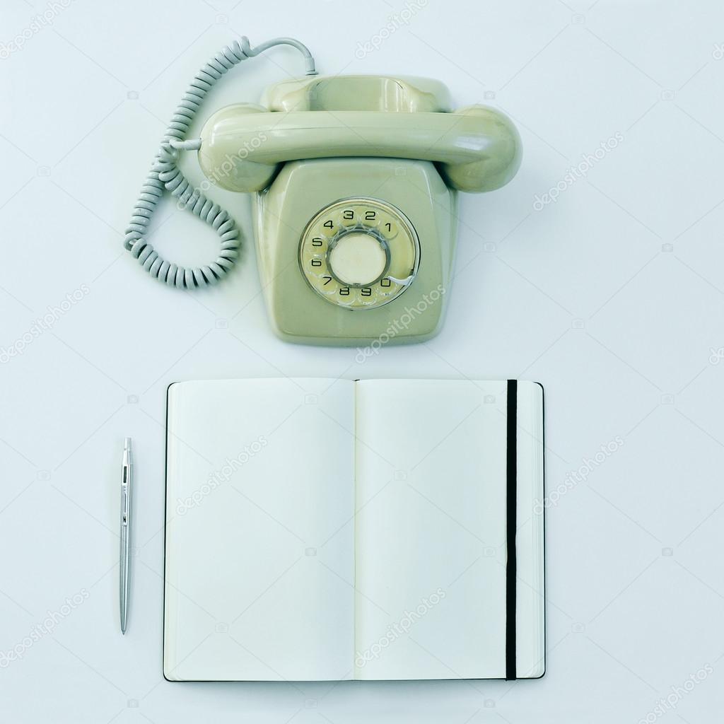 Rotary telephone, pen and blank notepad
