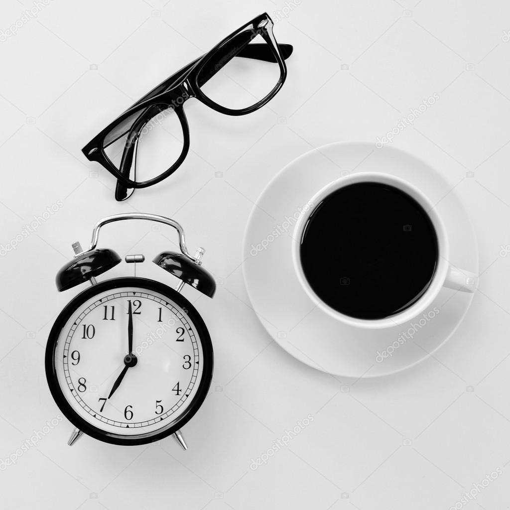 eyeglasses, alarm clock and coffee