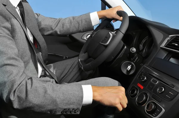 Giovane in giacca e cravatta alla guida di una macchina — Foto Stock
