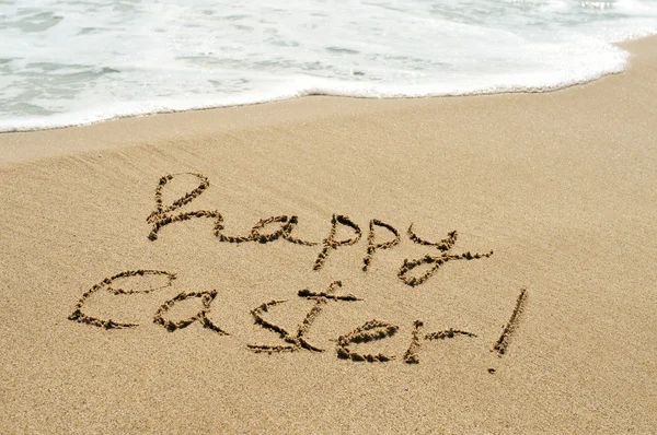 Happy easter written in the sand of a beach — Stock Photo, Image