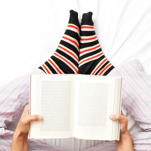 Joven leyendo un libro en la cama — Foto de Stock