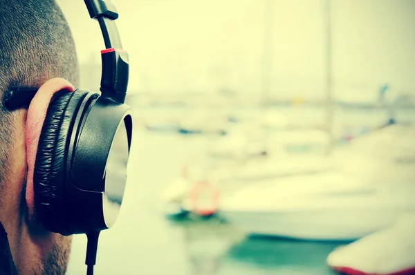 Ung man lyssnar på musik vid havet — Stockfoto