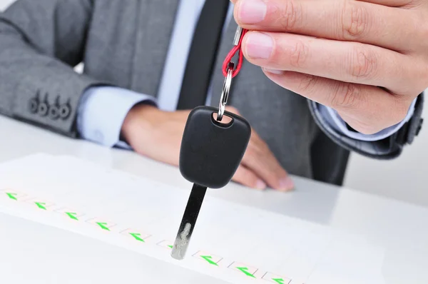 Homme au bureau donnant une clé de voiture — Photo