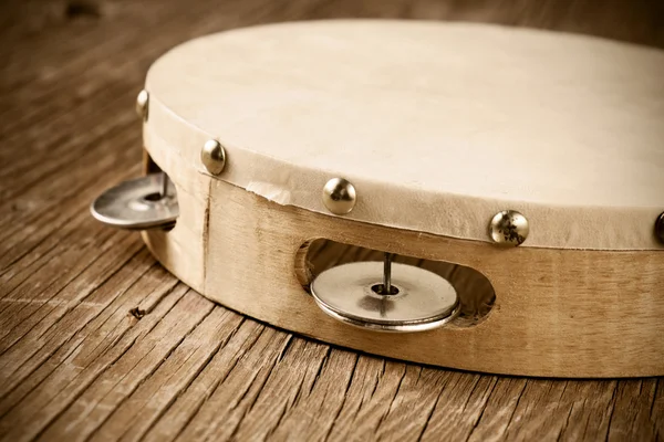 Tambourine on a rustic wooden table, retro look — Stock Photo, Image