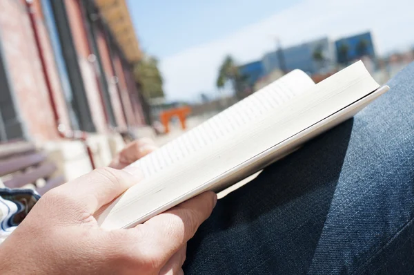 Jonge man lezen van een boek buitenshuis — Stockfoto