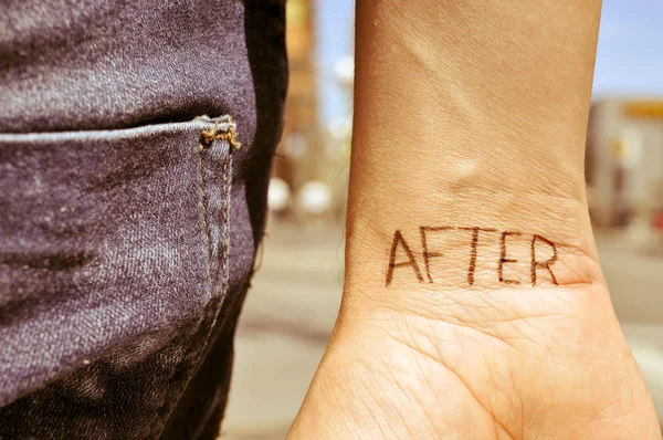 Jovem com a palavra depois de tatuado em seu pulso — Fotografia de Stock